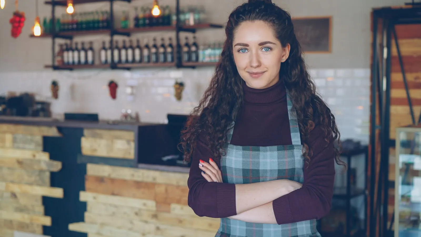 A small-business owner standing in her cafe in front of the counter
