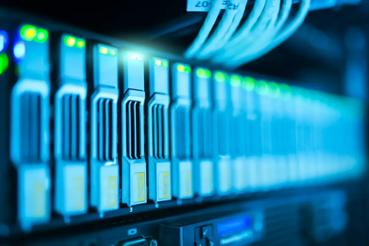 Server rack with rows of blue-lit blade servers receding into the distance