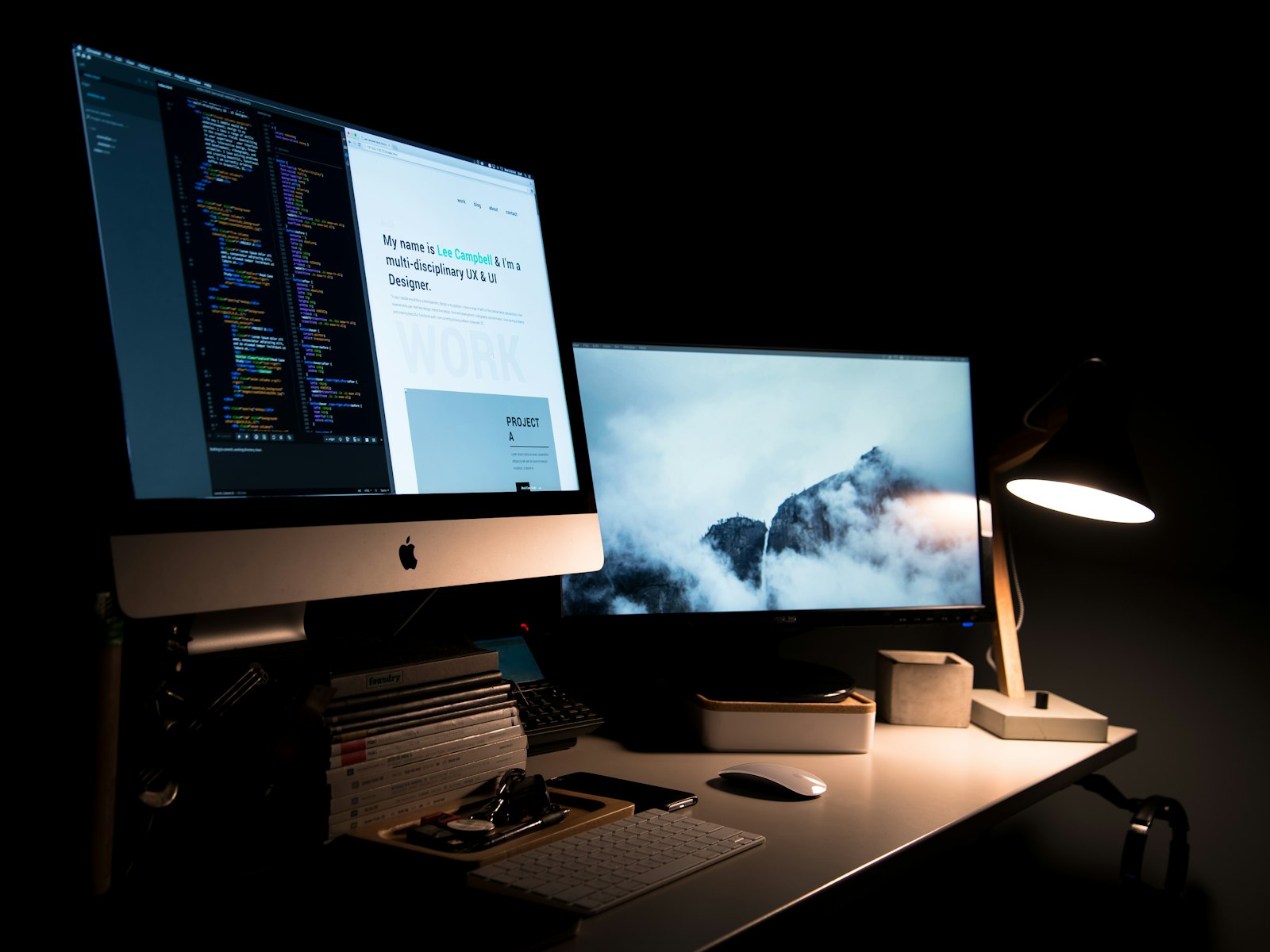 A UX designer’s setup with code on screen and a landscape display
